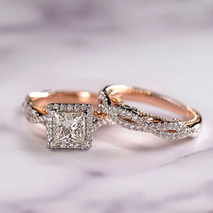 Set di fedi nuziali bicolore in oro rosa con halo princess e fascia con pavé intrecciato