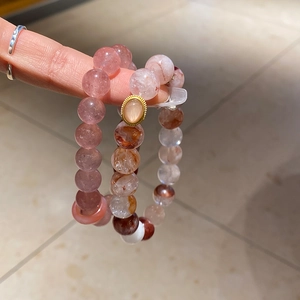 Detail of red strawberry quartz and pearl beaded bracelet with a gold metal clasp