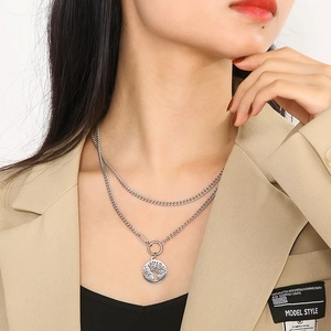 Double-layered silver Cuban chain necklace with Tree of Life pendant worn by model