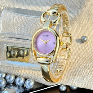 Elegant gold ladies watch with purple dial and horsebit bracelet on luxury fabric