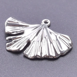 Vue macro du pendentif feuille de ginkgo argenté avec texture métallique détaillée