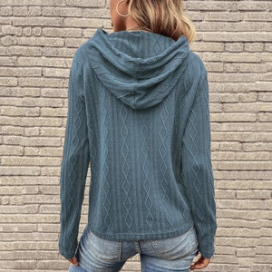 Dettaglio del retro di una felpa blu in maglia con trama a trecce e rombi