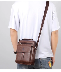 Rear view of model wearing the vintage brown leather crossbody bag with logo detail