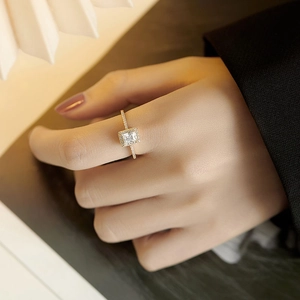 Elegant gold square halo ring with clear zircon stones shown on female finger