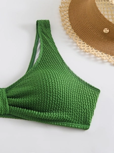 Detailed macro view of green crinkle texture bikini top with neat stitching and white lining