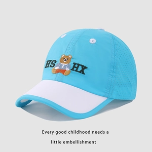 Detail of blue and white kids baseball cap featuring breathable mesh and bear embroidery
