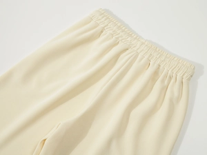 Macro detail of the elastic waistband and ribbed texture on beige knitted sports shorts