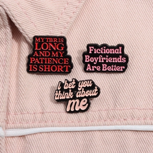 Detailansicht lustiger Emaille-Slogan-Pins am Kragen einer rosa Jeansjacke