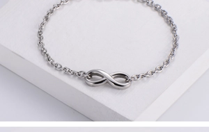 Macro detail of silver infinity symbol bracelet with polished stainless steel chain links