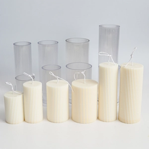 Detailed view of clear acrylic pillar molds and matching ribbed texture candles in white