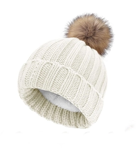 Close-up of thick fleece lining and fluffy faux fur pompom on knitted winter beanie