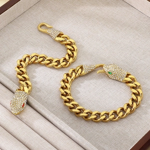 Golden Cuban chain snake bracelet with pavé rhinestones and red or green gem eyes
