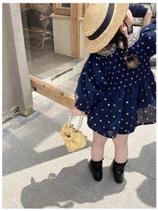 Detail of navy blue girls dress with gold heart prints and delicate lace collar