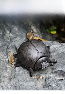Macro shot of vintage cast iron ladybug key box with textured dots on dark bronze shell