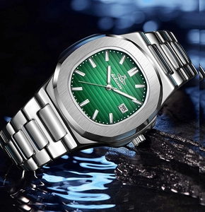 Macro shot of silver steel watch with green dial and date on wet stone with reflection