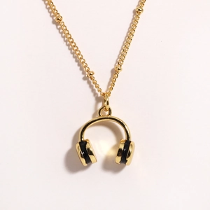 Macro view of golden headphone pendant necklace with beaded stainless steel chain