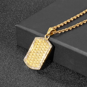 Detail of gold rectangular dog tag necklace with cubic zirconia and woven metal texture