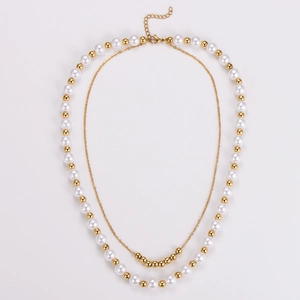 Close-up of double-layered pearl and gold bead necklace with lobster clasp and chain