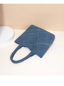 Detailed close-up of woven denim tote bag with checkerboard pattern and matching handle