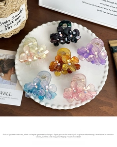 Detail of floral acetate hair claws with colorful rhinestones in a ceramic dish