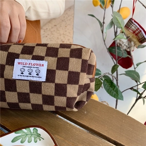 Détail macro de la pochette en velours côtelé damier marron avec étiquette Wild Flower