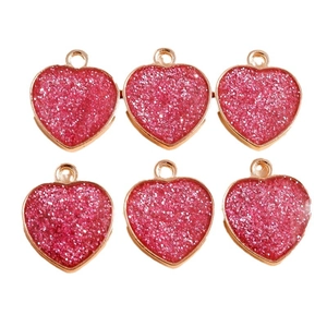 Pack of six pink glitter heart pendants with gold alloy borders on a white background