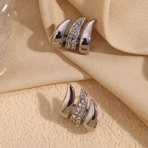 Detailed view of silver curved triple-claw earrings featuring sparkling white zircon inlay