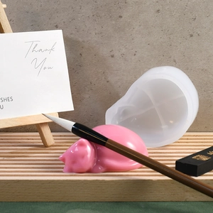 Macro detail of cat-shaped silicone mold with finished resin crafts on a wooden tray