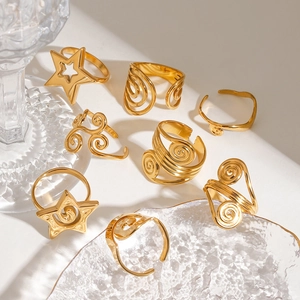 Detail of 18K gold-plated stainless steel rings with star and spiral patterns