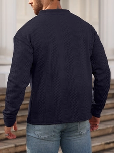 Detail view of navy blue long sleeve knit sweater featuring textured jacquard pattern