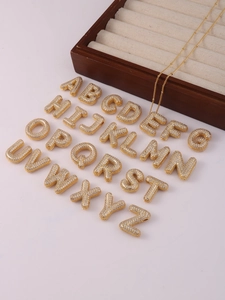 Detail view of 26 gold-plated alphabet pendants with sparkling zircon pavé micro-inlay