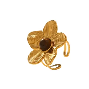 Macro detail of vintage gold flower ring with brown gemstone and adjustable open band