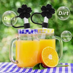 Black peach flower silicone straw cover protecting against dust and dirt on a straw