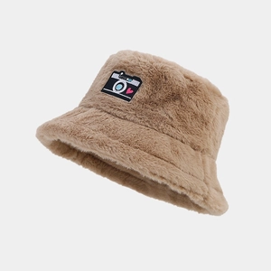 Detail view of brown plush bucket hat with camera patch and red heart embroidery