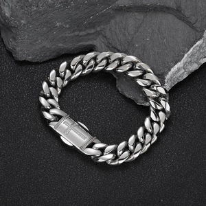 Polished stainless steel Cuban link bracelet for men with cross clasp on rock background