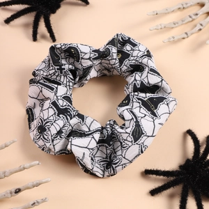Detail of Halloween scrunchie with spider and witch hat prints on white fabric