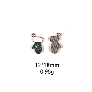 Detailed view of forest green Christmas glove charms with white snowflake pattern