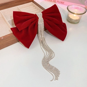 Close-up of red velvet bow hair clip with elegant silver rhinestone tassels decoration