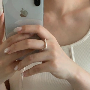 Detail of 925 sterling silver knotted ring on finger during a mirror selfie shoot