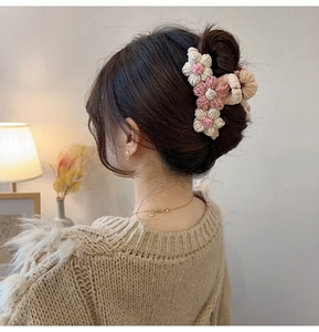 Side view of handmade crochet flower hair claw clip worn on a bun for an elegant style
