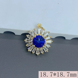 Detailed view of 18.7mm sunflower pendant with blue gem and clear crystals in gold