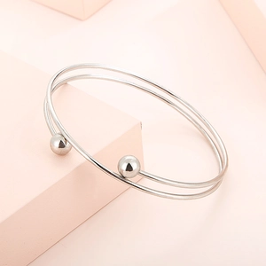 Minimalist silver double-band open cuff bracelet with round beads on pink display stand