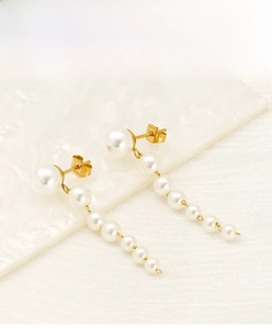 Macro view of long pearl tassel earring showing the S.Steel engraving on the gold stud