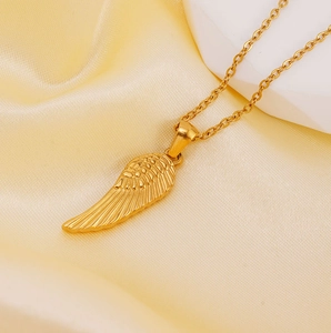 Chic 18K gold plated stainless steel wing pendant necklace on elegant gold satin fabric