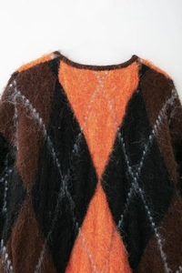 Détail du pull en mohair montrant le motif à losanges orange et brun chiné