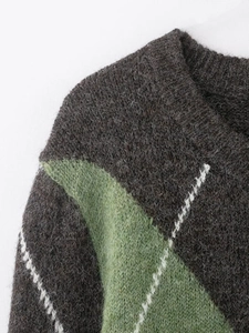 Détail du col en V d'un pull en maille avec texture grise et motifs losanges verts