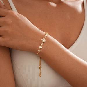 Detailed view of adjustable gold snowflake flower bracelet with zircon stones on wrist
