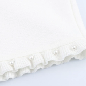 White knit dress edge featuring elegant scalloped hem and delicate faux pearl decorations