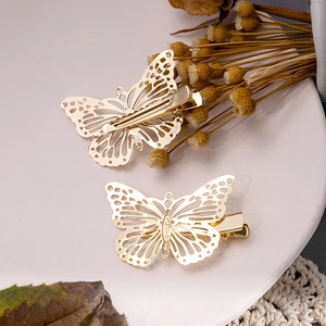 Gros plan de pinces à cheveux papillon dorées montrant les détails avant et arrière