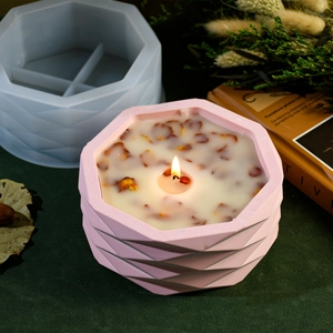 Detailed view of pink geometric faceted candle holder next to its silicone mold